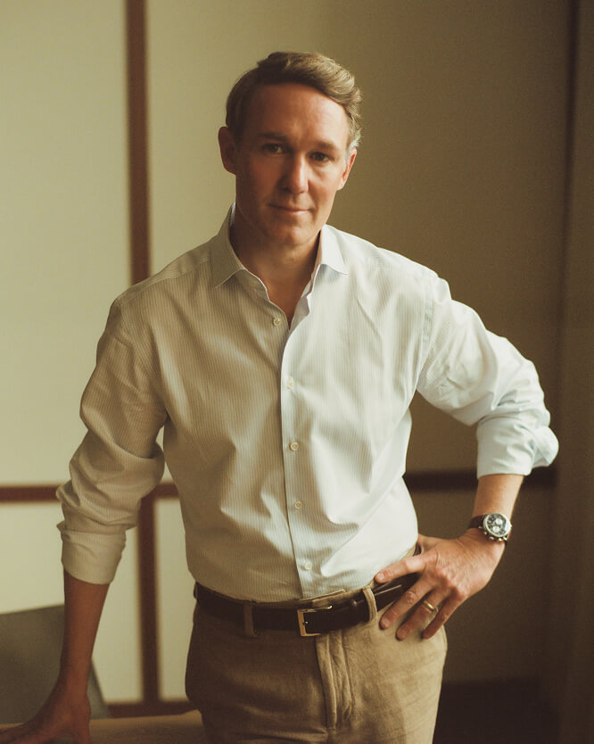 This image depicts a portrait of a BHC team member smiling in a suit