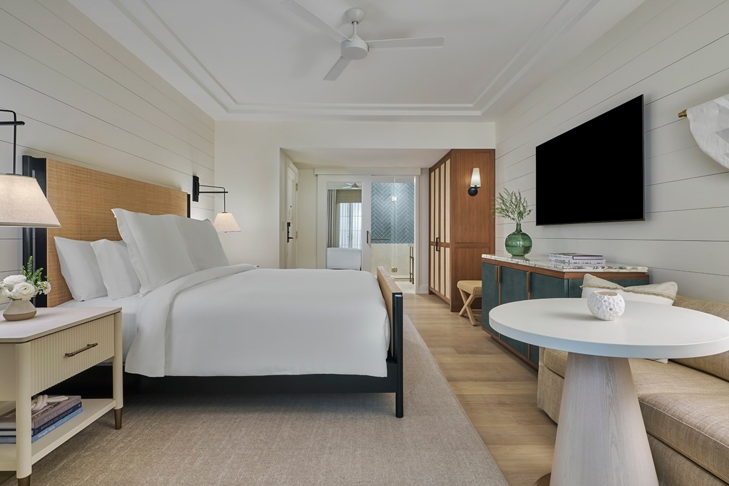 this image depicts a hotel bedroom with a freshly made bed