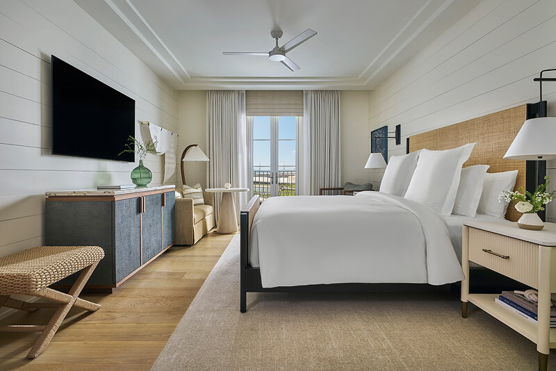 this image depicts a hotel bedroom with a freshly made bed