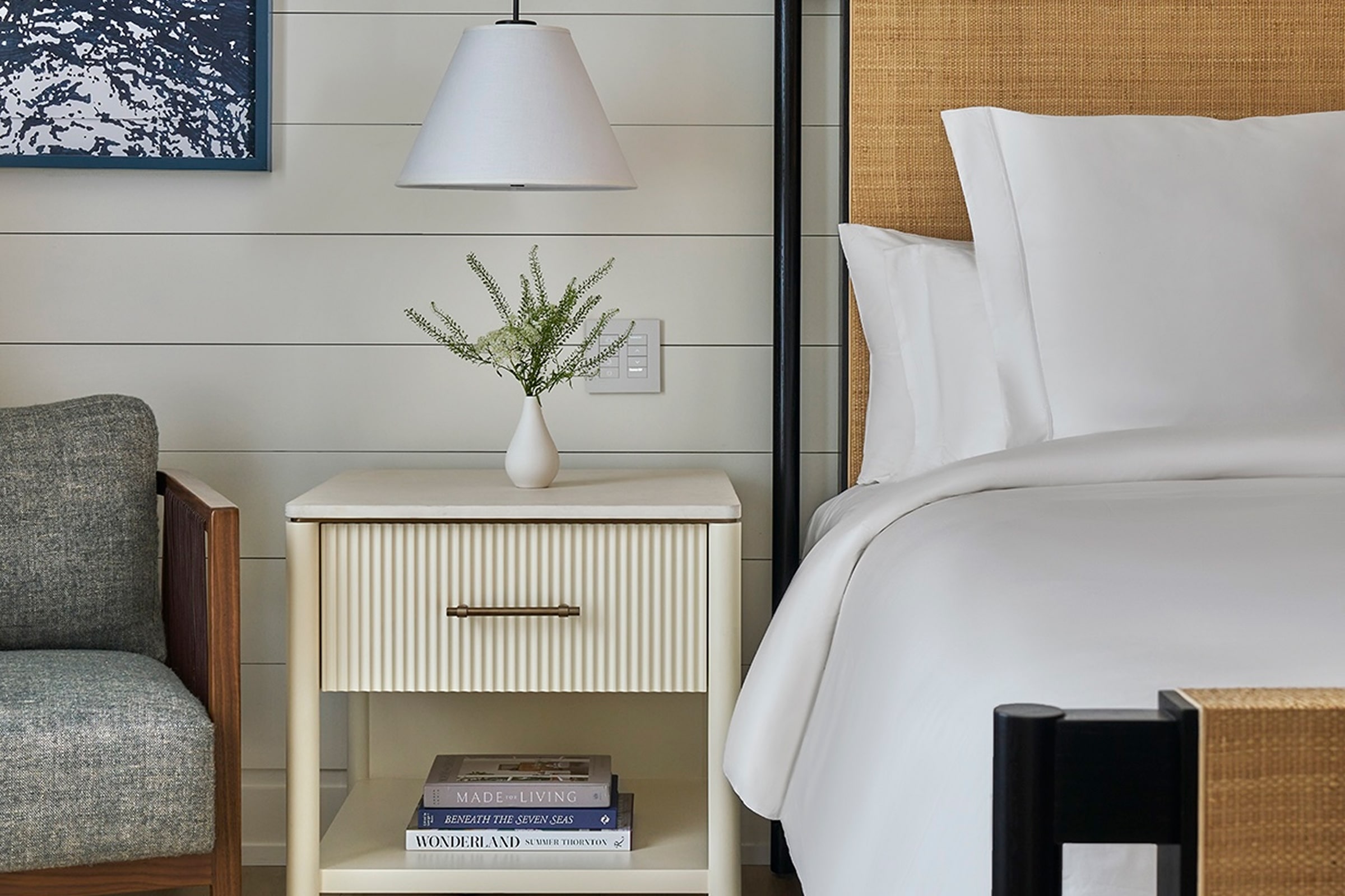 this image depicts a hotel bedroom with a freshly made bed