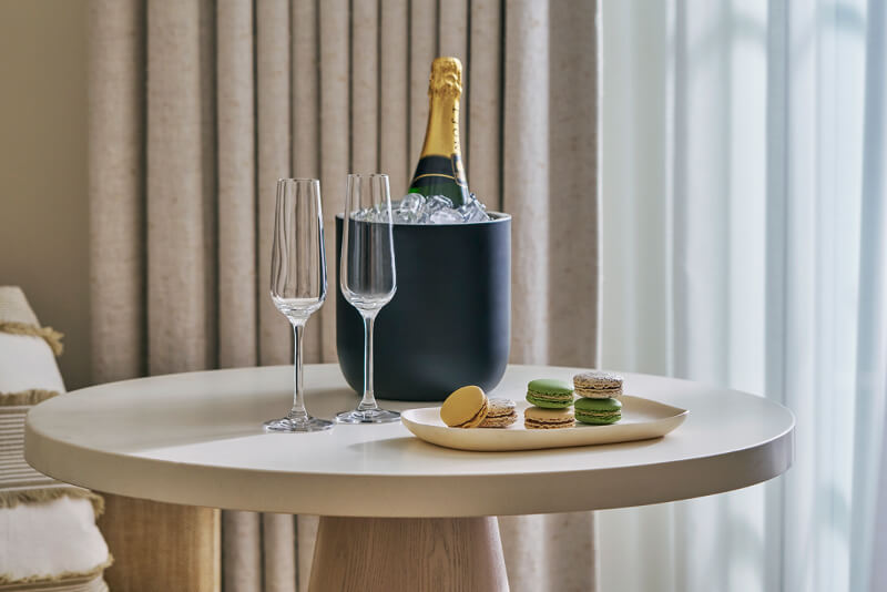 this image depicts champagne beside cookies on a table