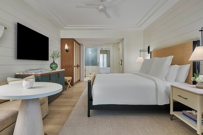 this image depicts a hotel bedroom with a freshly made bed