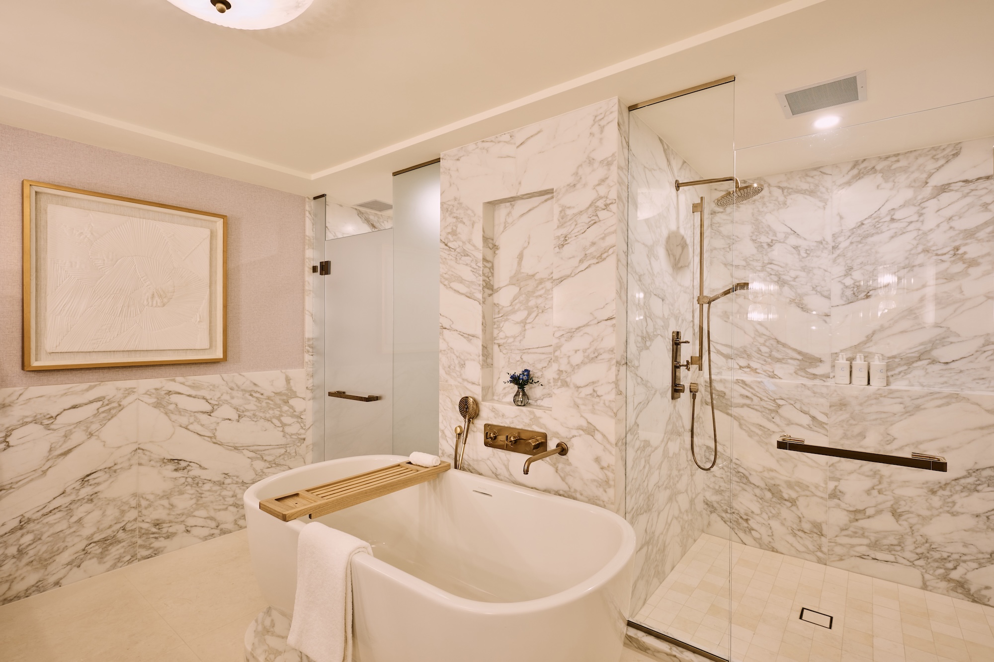 Image of a white marble bathroom with rub and shower shown.